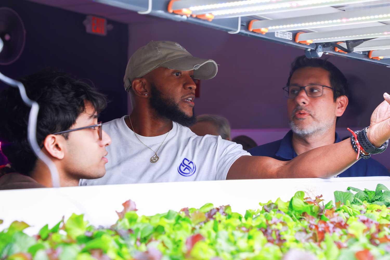 Desmond Hayes explaining a hydroponic system to visitors at iA Labs